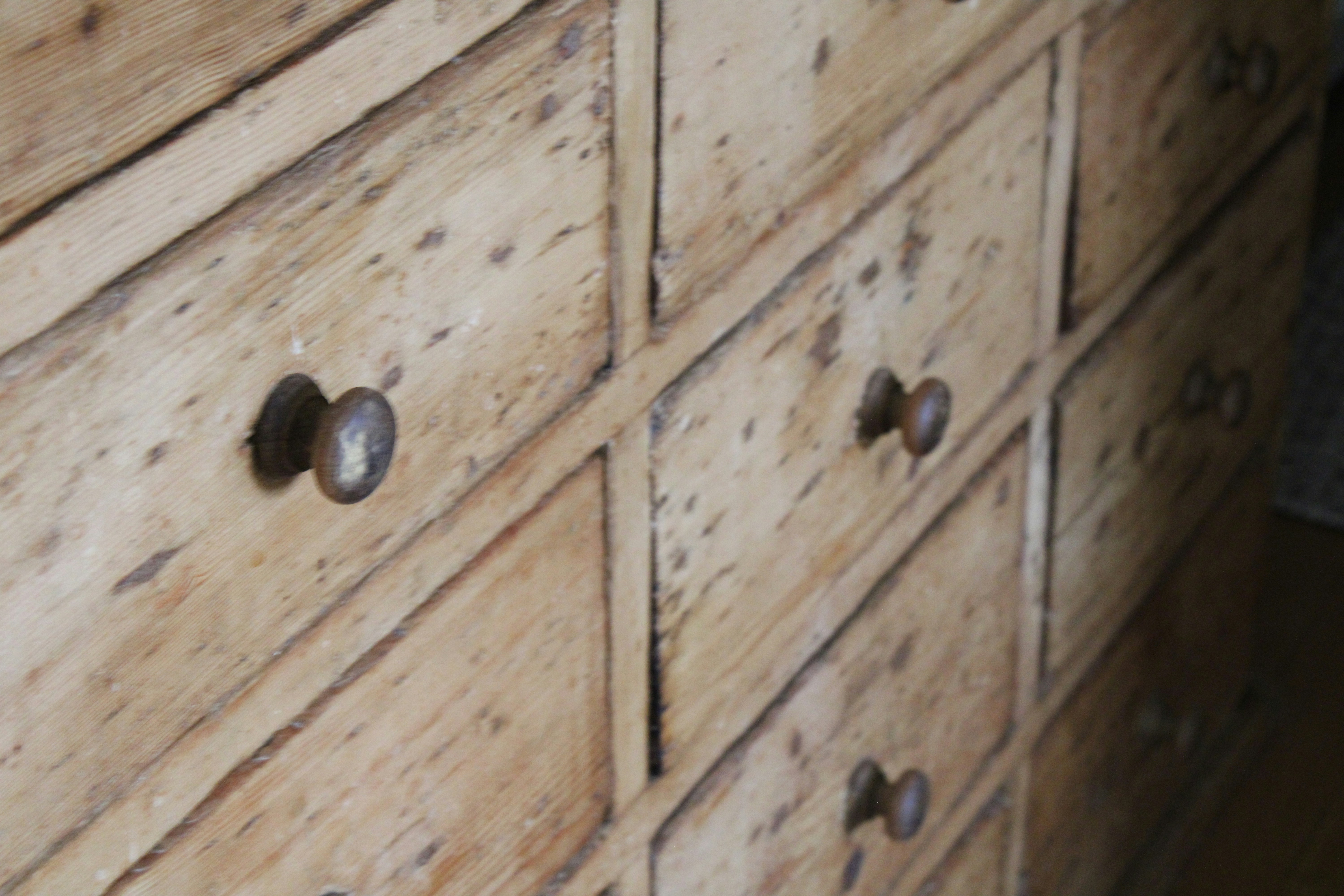 a close up of a wooden dresser with knobs