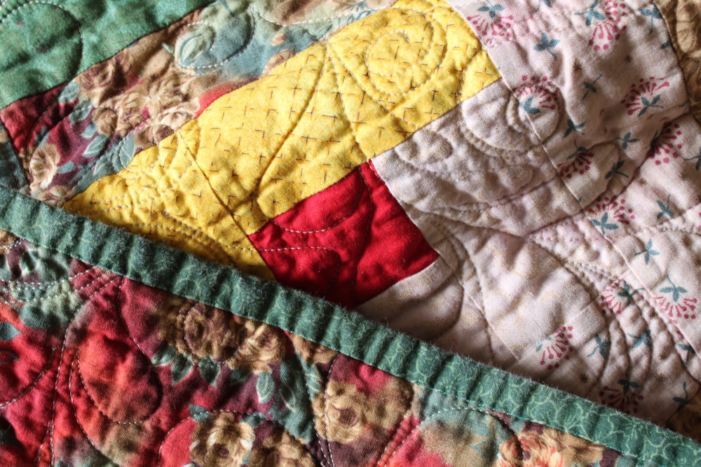 a close up of a colorful quilt on a bed