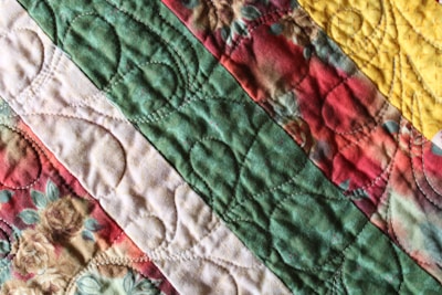 a close up of a colorful quilt on a bed