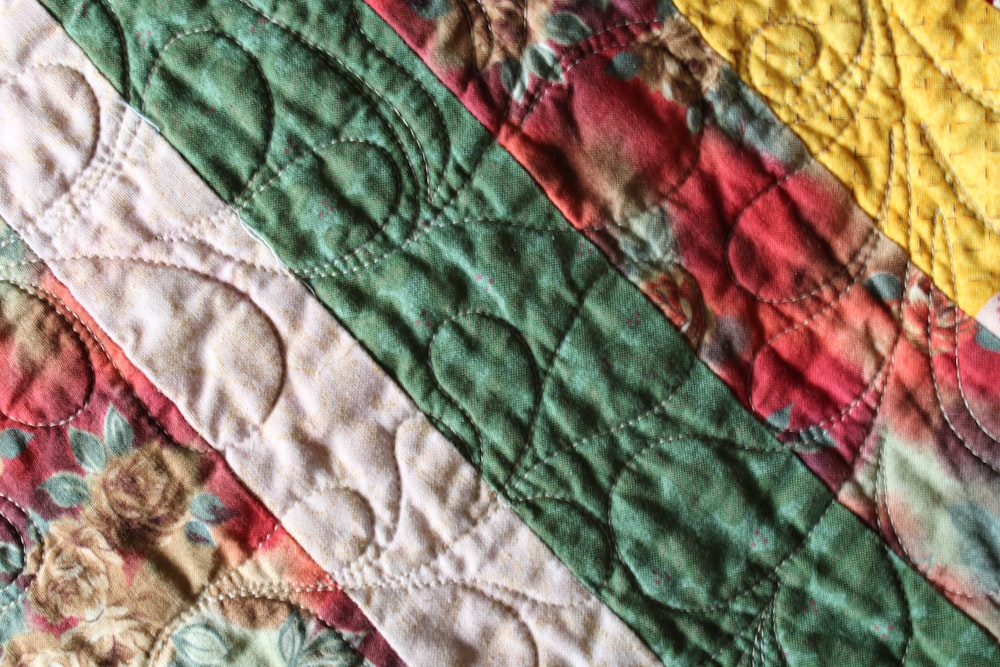 a close up of a colorful quilt on a bed