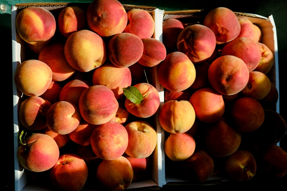 a bunch of peaches in a box on a table