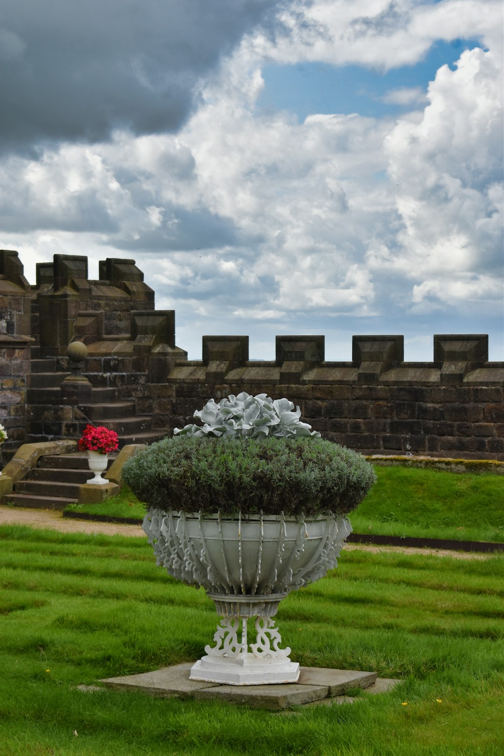 a large vase with a plant in it on a lawn