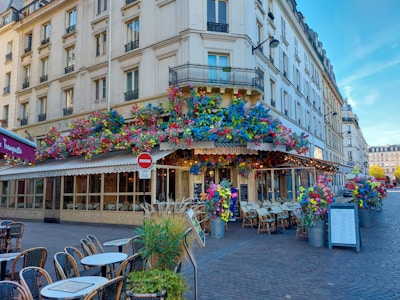 A charming café terrace bustling with people, framed by historic city walls.