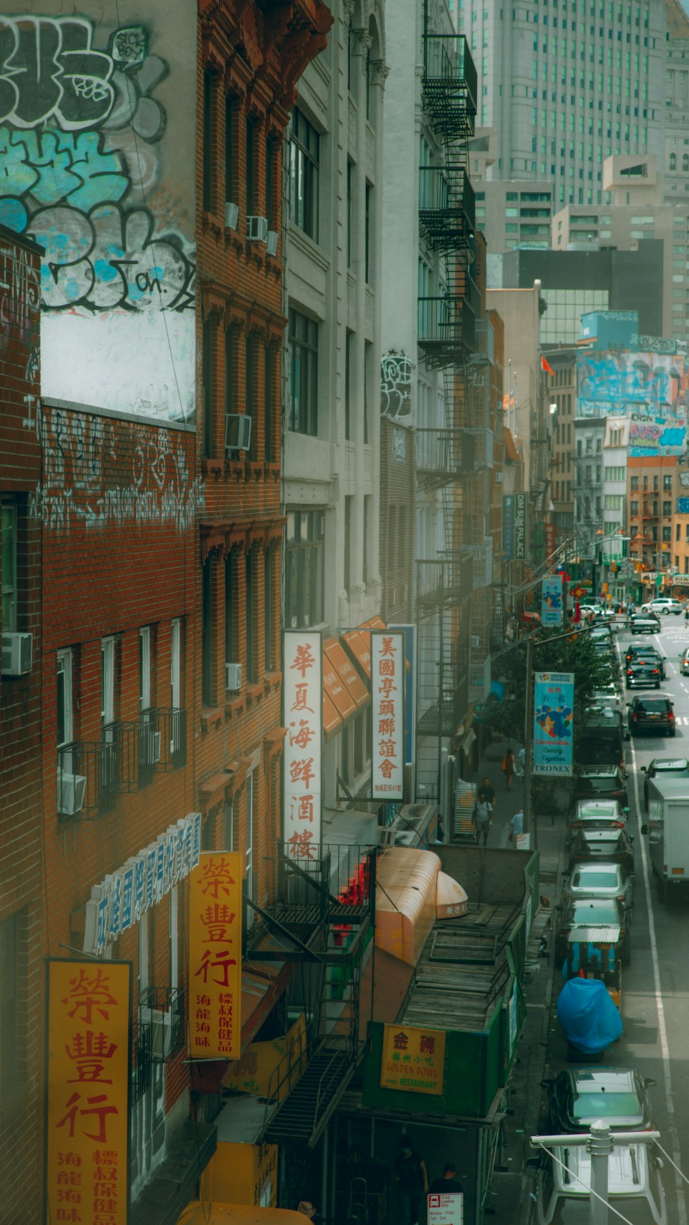 a city street filled with lots of traffic next to tall buildings