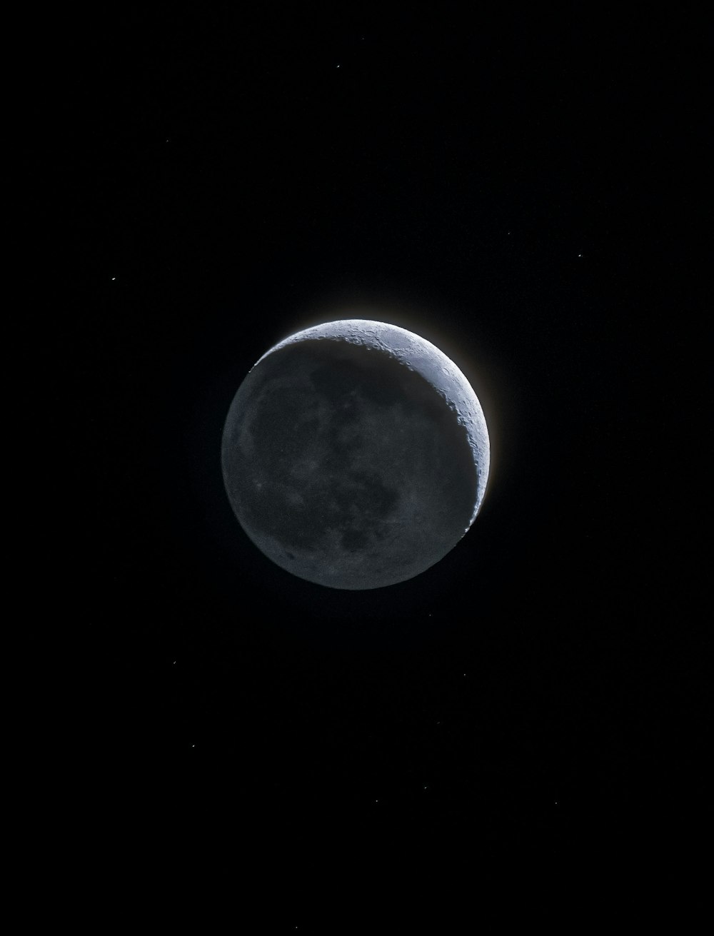 the moon is seen in the dark sky