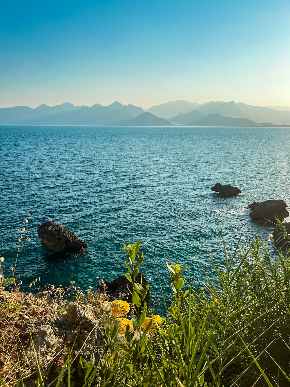 a large body of water surrounded by a lush green hillside