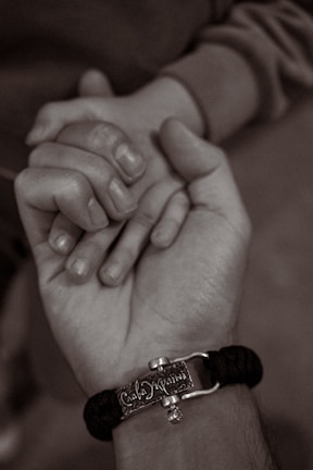 A close-up of a survivor’s hand holding a Magen Amo emblem, representing protection and hope.