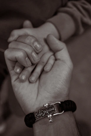 Close-up of hands holding a small, intricate amulet symbolizing love binding rituals.