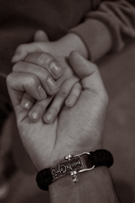 Close-up of hands holding a supportive bracelet symbolizing strength and sobriety.