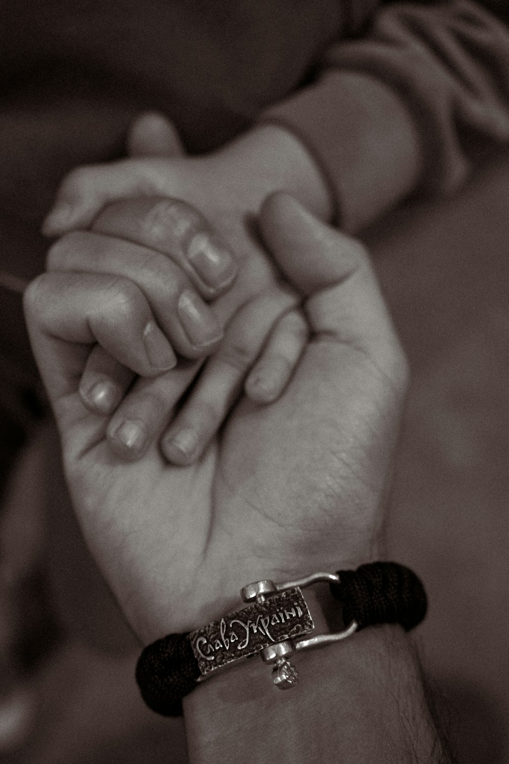 a black and white photo of a couple holding hands