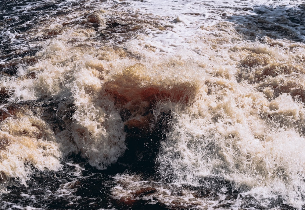 a large body of water covered in brown and white foam