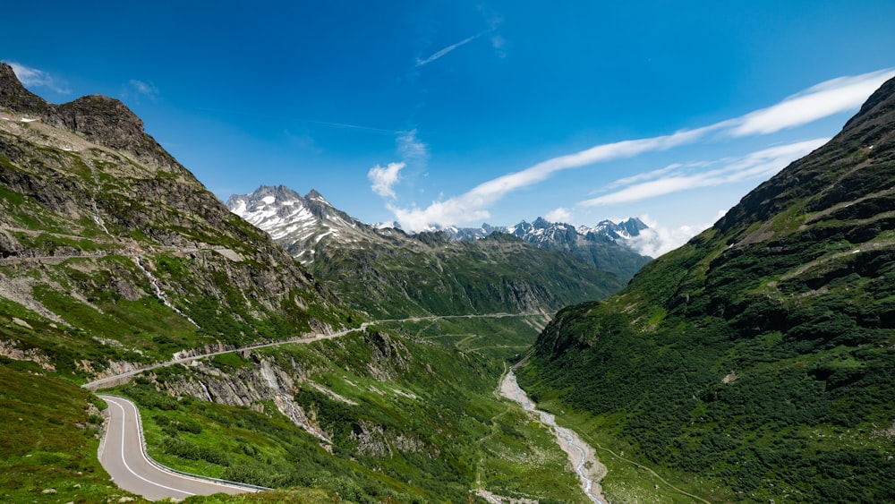 a scenic view of a winding road in the mountains