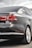 The image captures the rear view of a sleek, dark-colored sedan with tinted windows. The car appears modern and well-maintained, showcasing its taillights, rear badge indicating '2.0 TDI', and a clean, reflective surface with minor reflections.