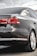 The image captures the rear view of a sleek, dark-colored sedan with tinted windows. The car appears modern and well-maintained, showcasing its taillights, rear badge indicating '2.0 TDI', and a clean, reflective surface with minor reflections.