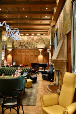 A softly lit, elegant hotel lounge with a grand piano and subtle golden accents.