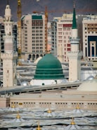 a large building with a green dome in the middle of a city