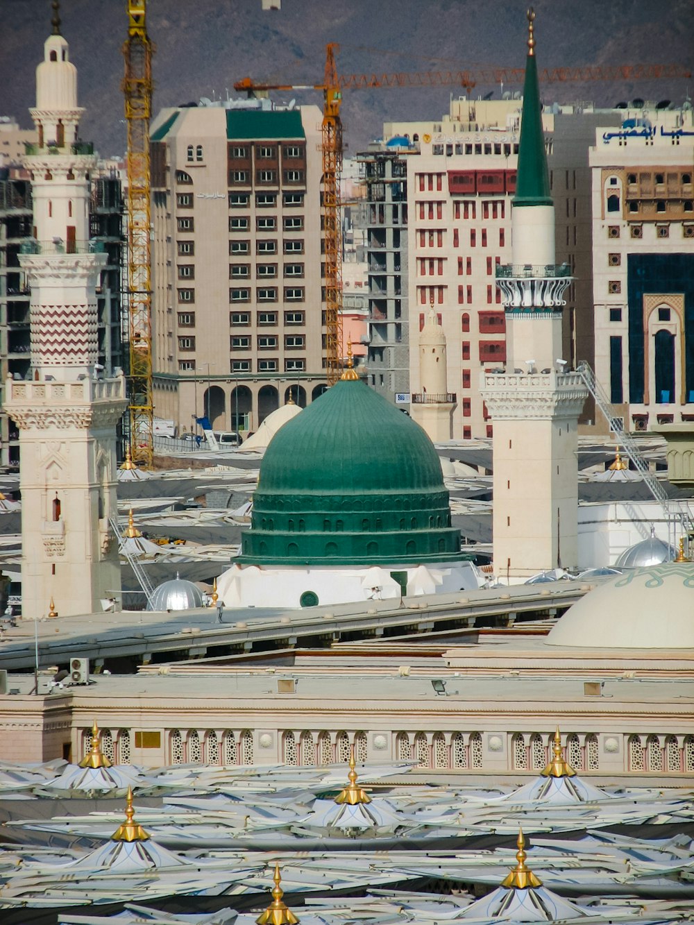 a large building with a green dome in the middle of a city