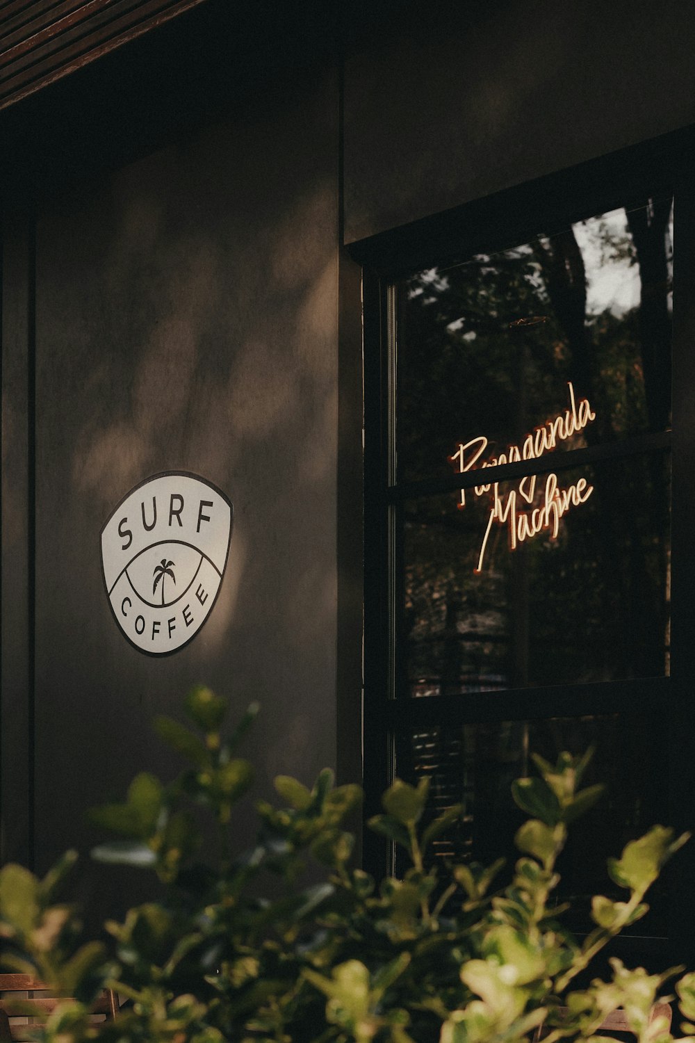 a coffee shop with a neon sign above the door