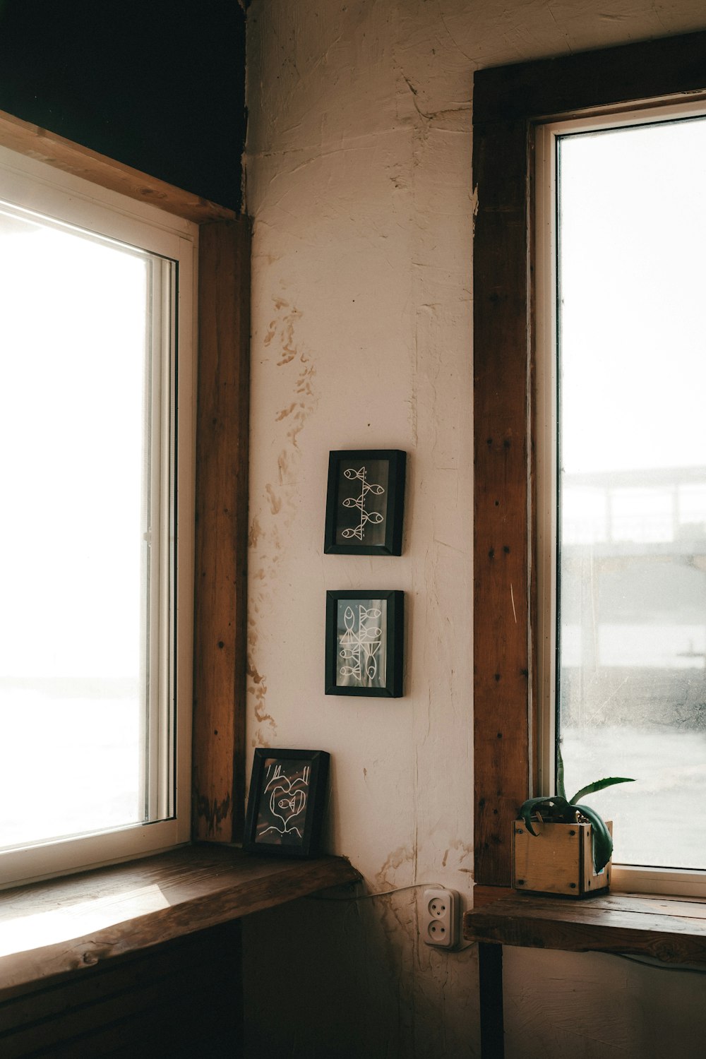 a corner of a room with three framed pictures on the wall