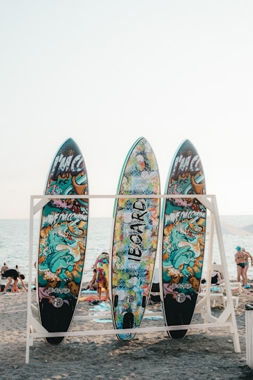A vibrant surfboard displayed against a sunny beach backdrop.
