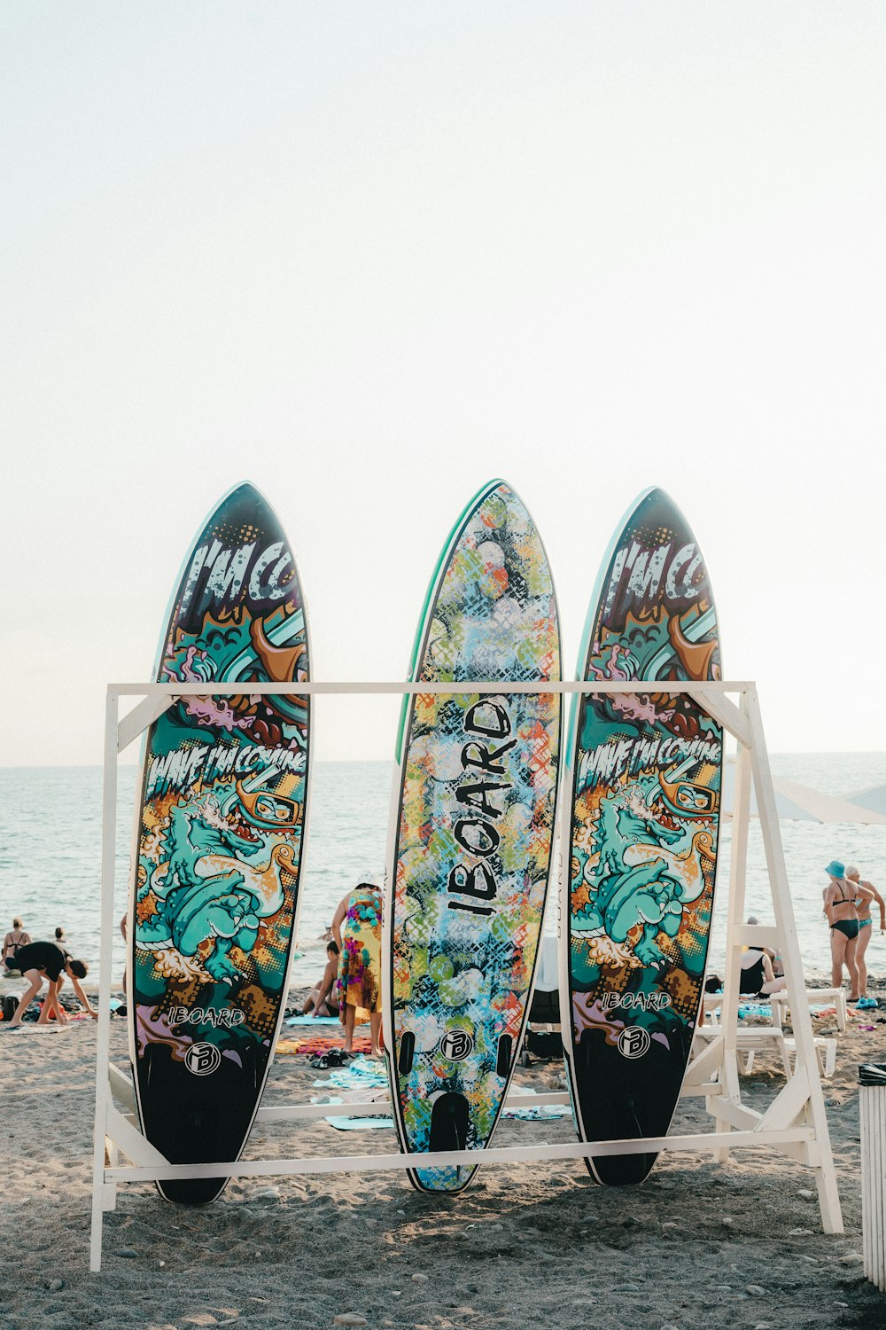 three surfboards are lined up on the beach