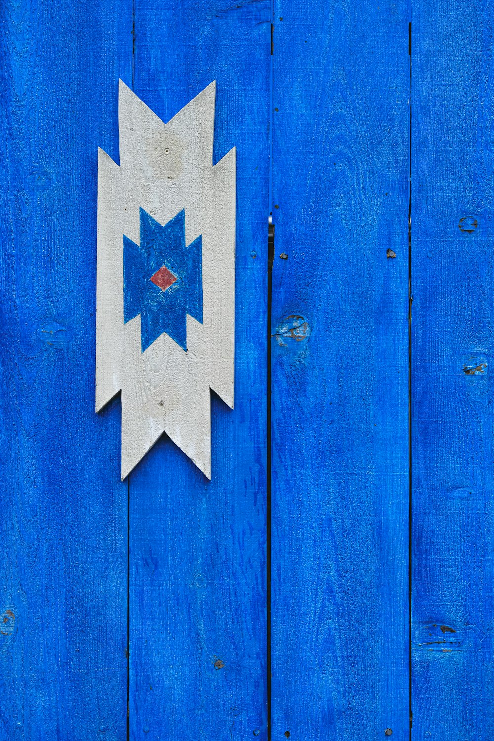 a blue wooden wall with a white and blue arrow on it