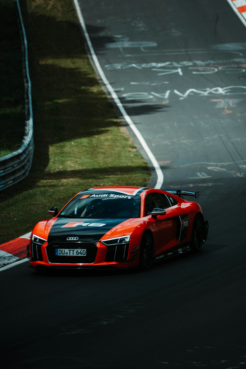 a red sports car driving down a race track