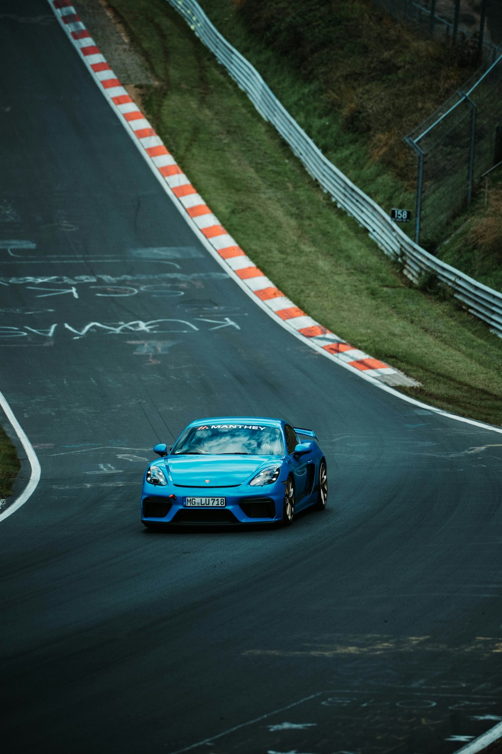 a blue sports car driving down a race track