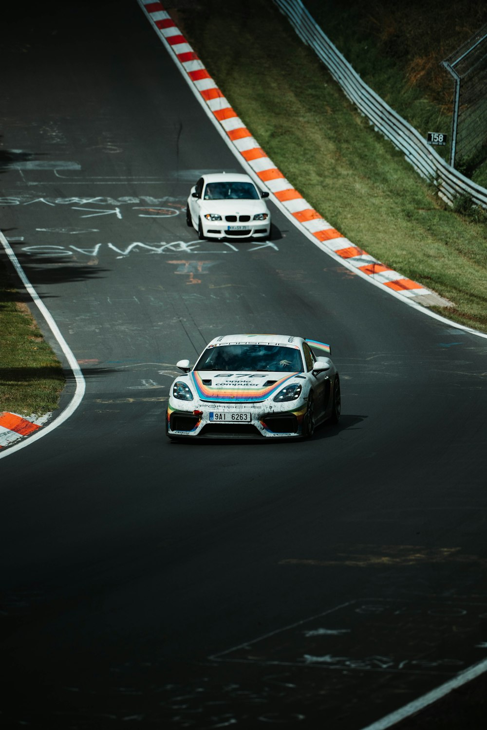 a couple of cars driving down a race track