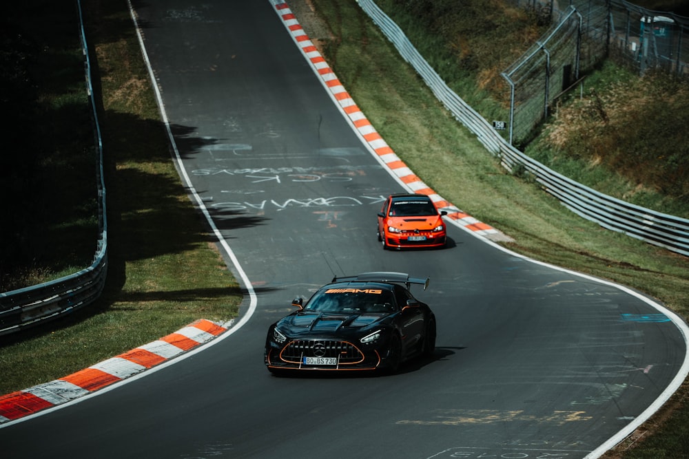 a couple of cars driving down a race track