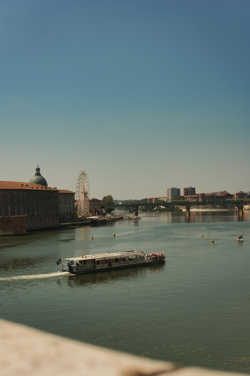 a boat traveling down a river next to a bridge