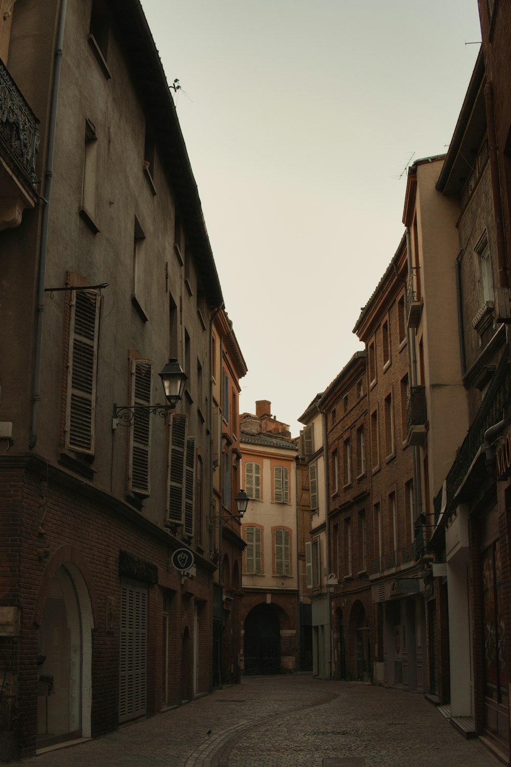 a narrow street with a few buildings on both sides