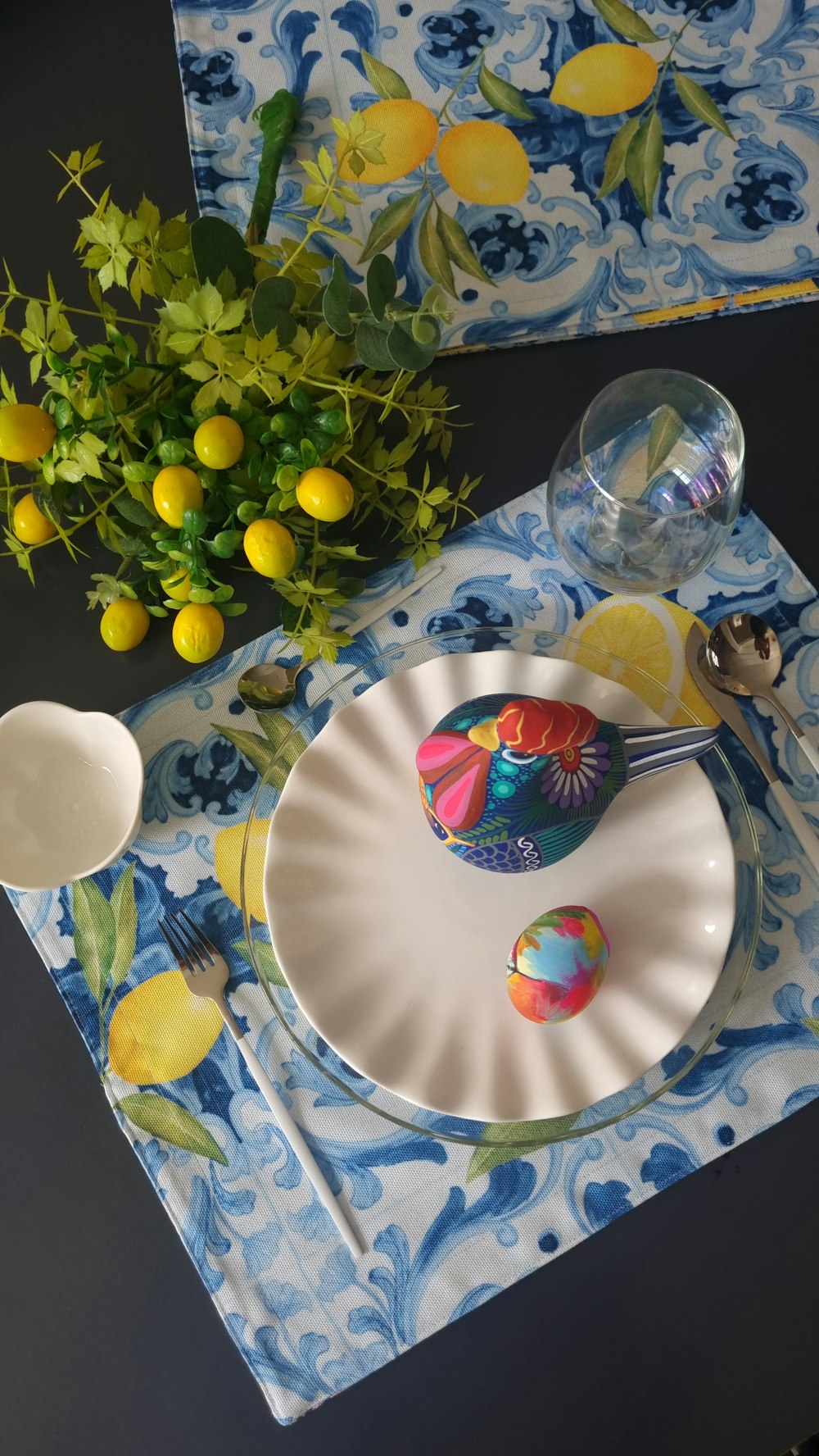 a table set with plates, silverware and a vase of flowers