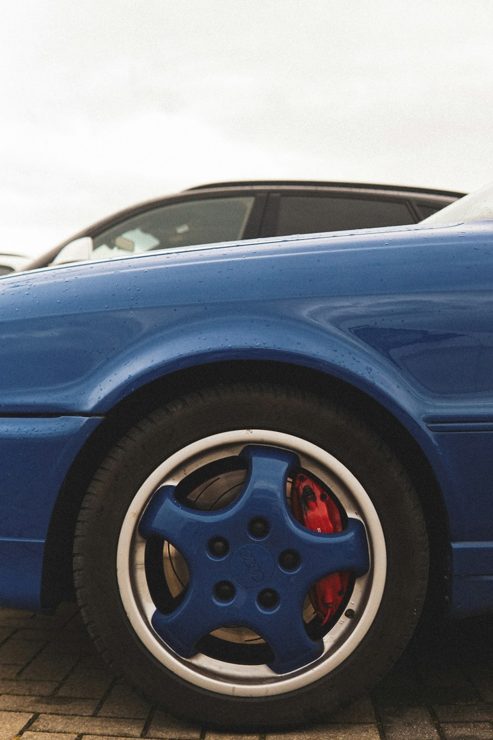 Un auto deportivo azul estacionado en un estacionamiento