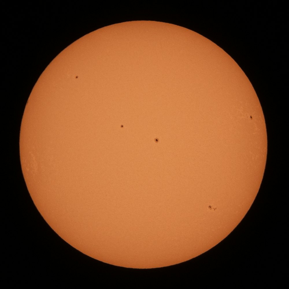 a very large orange sun in the dark sky