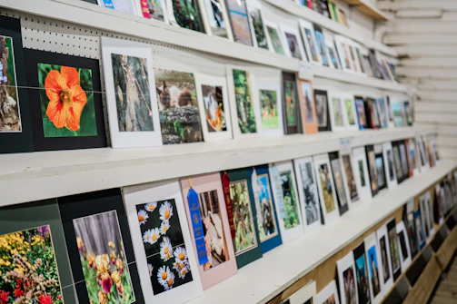 A neatly arranged collection of framed prints leaning against a white wall with subtle shadows.