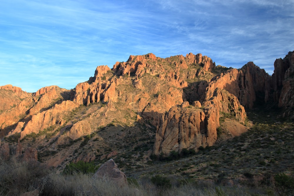 a rocky mountain with a blue sky in the background