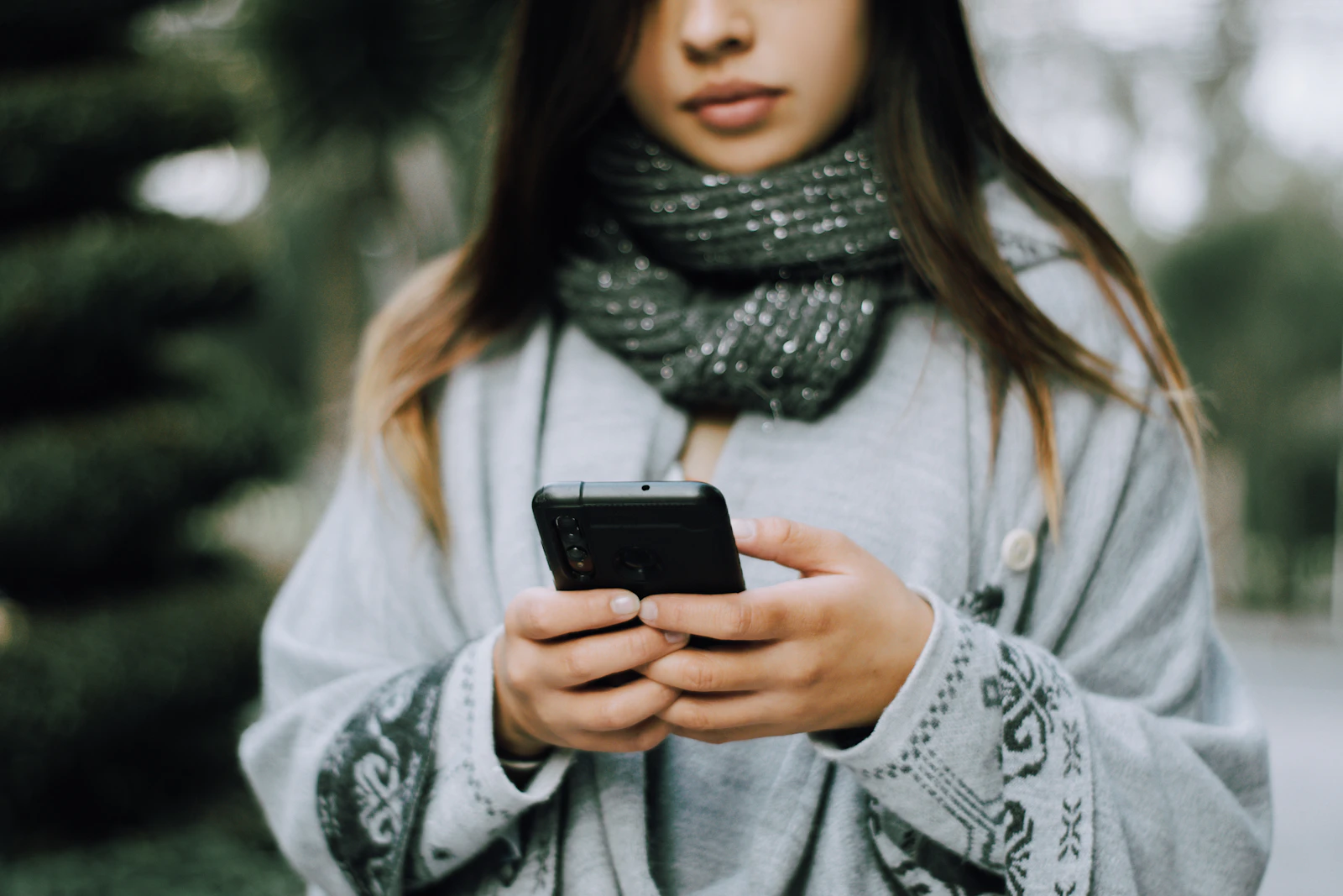 Teenager holding a smartphone outdoors