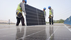 Solar PV modules being installed on a rooftop by skilled technicians.