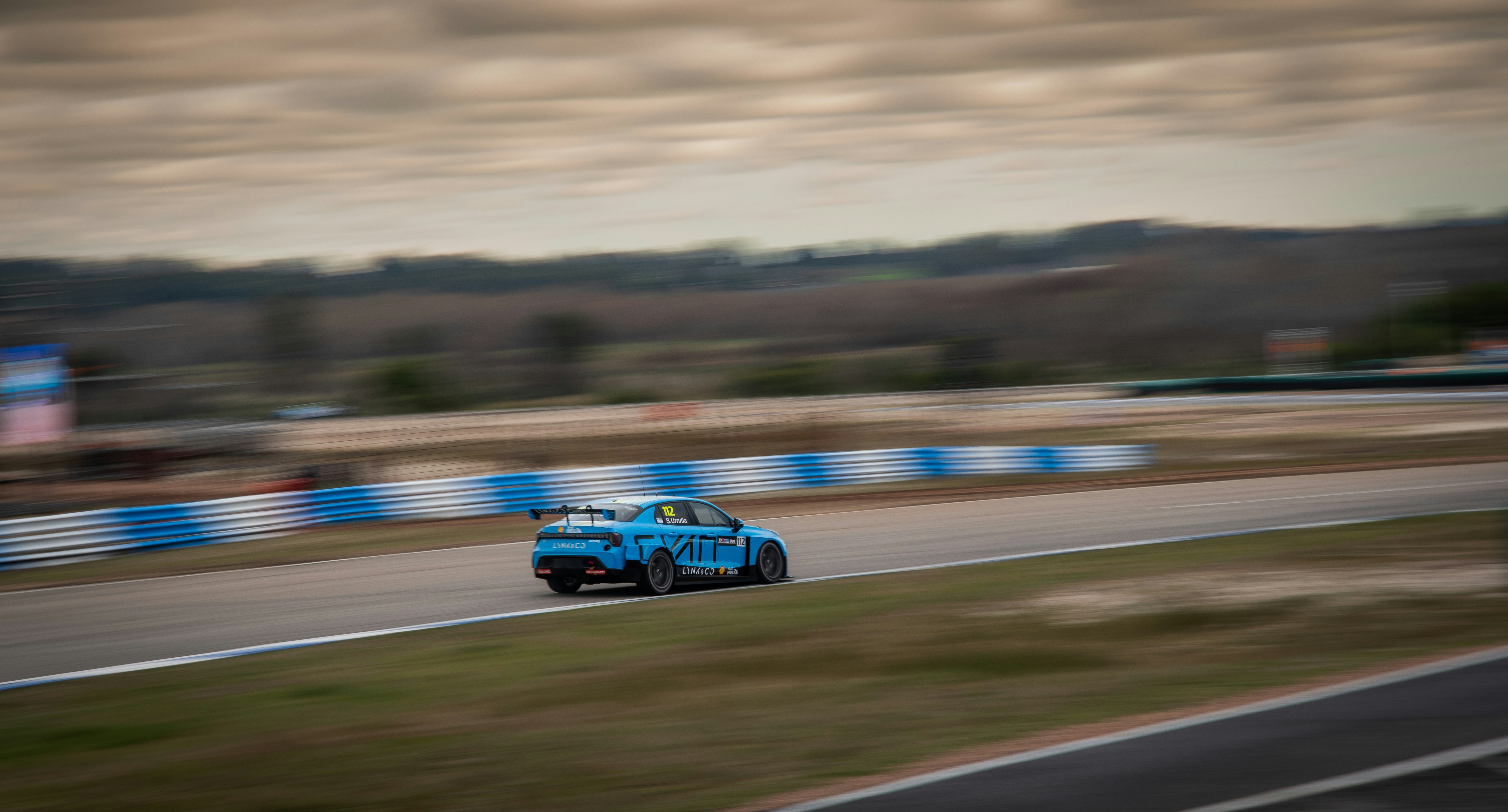 a blue car driving down a race track