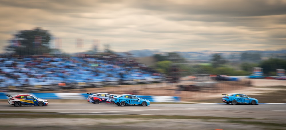 a group of cars driving down a race track