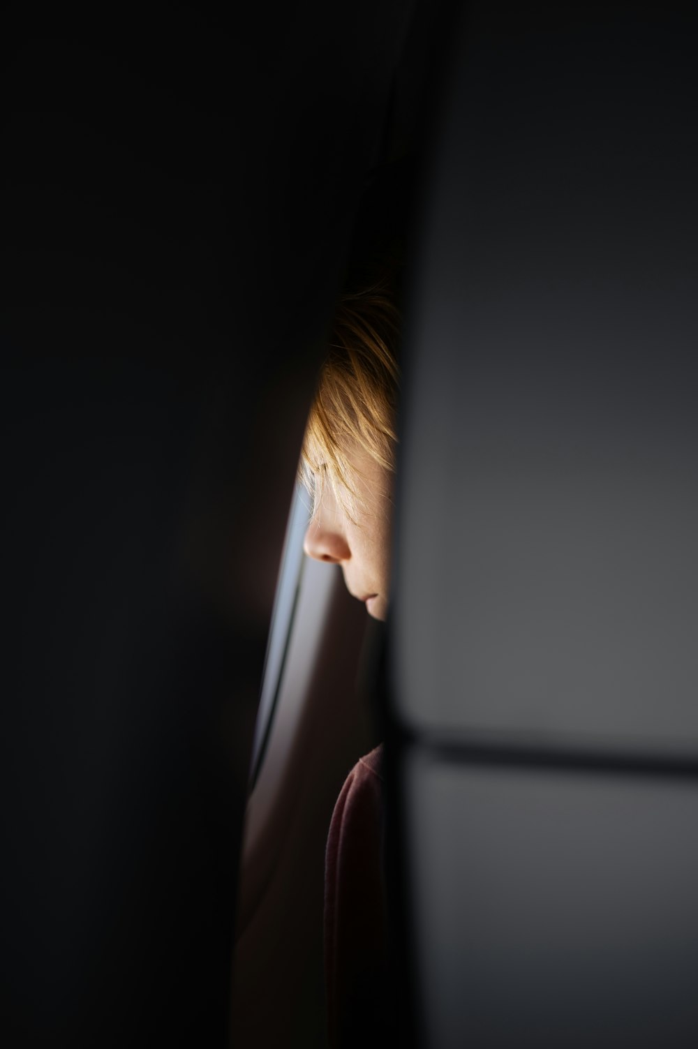 a young boy looking out the window of a plane