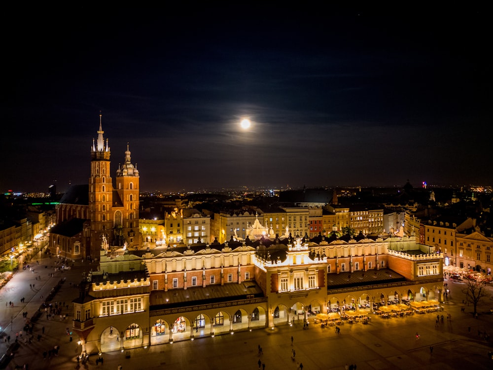 a city at night with a full moon in the sky