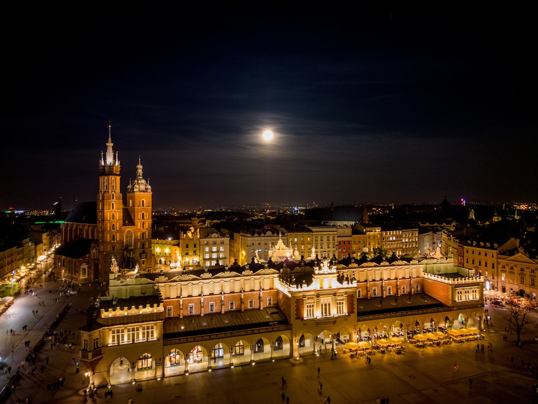 a city at night with a full moon in the sky,