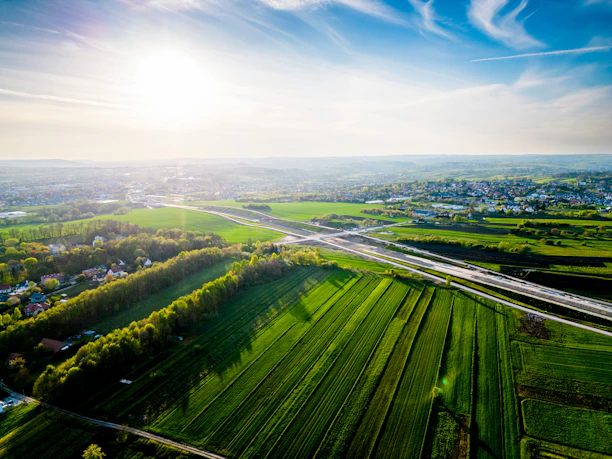 A scenic view of a parcel of land with clear skies and nearby roads, highlighting accessibility.