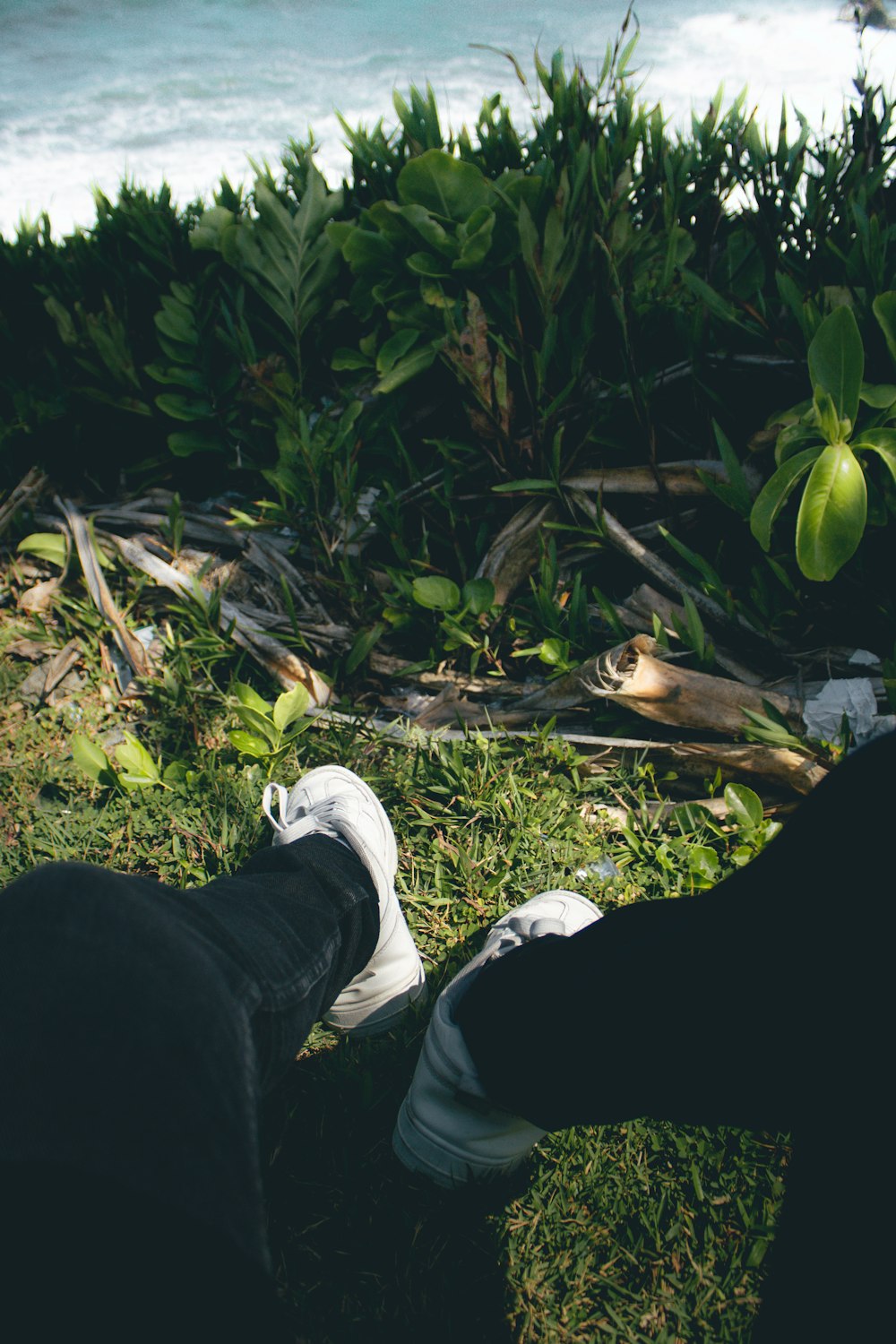 a person sitting on the grass with their feet up