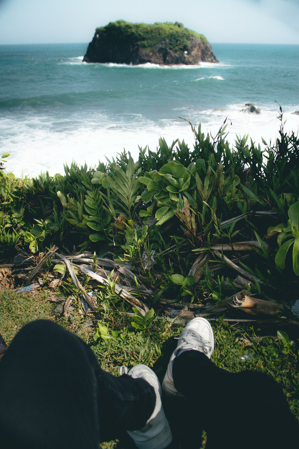 a person with their feet on the ground near the ocean