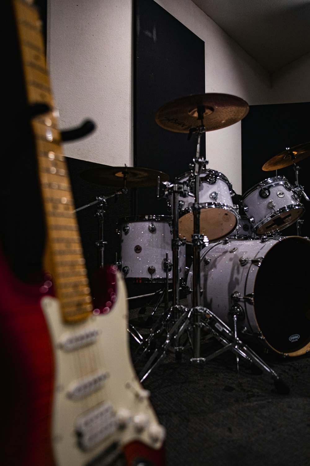 two guitars and a drum set in a room