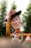 A smiling cowboy tipping his hat at a lively rodeo event under a clear blue sky.