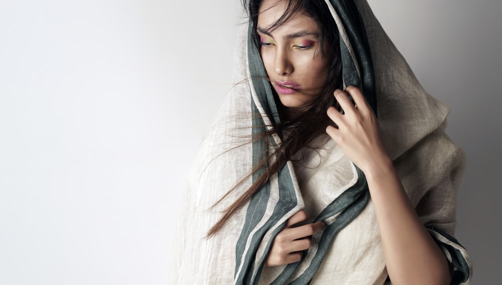 a woman wrapped in a blanket with her eyes closed
